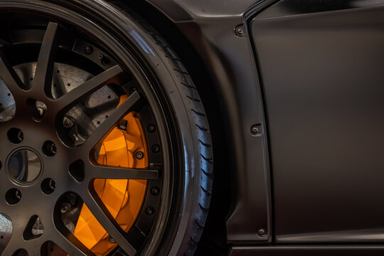Close up sport car wheel with orange disc brake pad