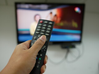 hand with the remote control television and presses the button.
