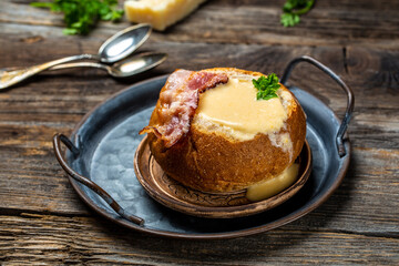 Bun with delicious hot cream soup with bacon. rustic style, delicious food