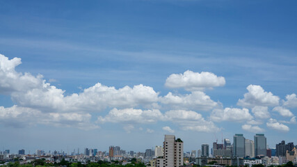 Fototapeta premium Outdoor white fluffy clouds on blue sky above city building