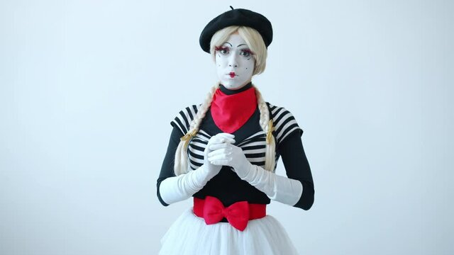 Slow motion of female mime artist moving hand showing so-so gesture standing alone on white background. Attitude and body language concept.