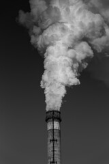 The thick smoke rises high from the industrial pipes. Pollution of the environment with waste...