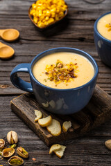 corn soup with pistachios and croutons on top, vertical image, Vegan cuisine. Food recipe background. Close up