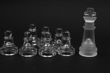 Obraz premium glass chess pawn and king piece above shot on black background. challenge and competition concept