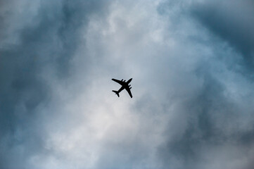 Fototapeta na wymiar silhouette of jet air craft passenger plane in cloudy sky with copy space