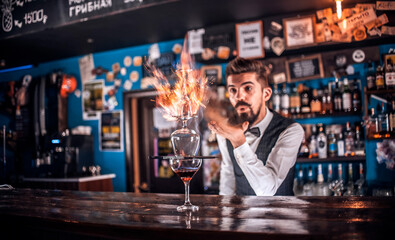Barman creates a cocktail behind the bar