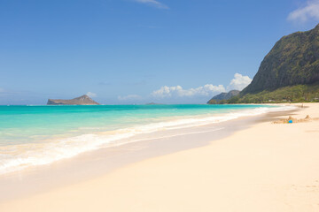 Empty Hawaiian beach with white sand and aqua blue water