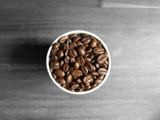 Top view Coffee beans in cup on wooden table