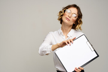 Business woman in a light shirt and a folder with documents in hands cropped view of work