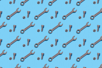 Naklejka premium Seamless regular pattern with wrench, bolt and nuts on a blue background. Hard light. Father's day holiday concept.