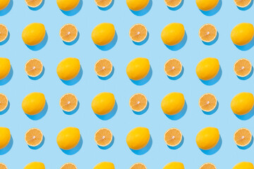 Seamless regular pattern with fresh lemons on a blue background. Hard light. Minimal summer composition.