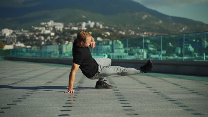 A young guy does morning exercises on a sunny day. A young man goes in for sports outdoors on the background of the sea