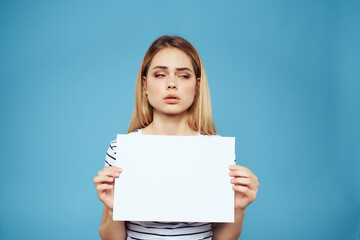 Fototapeta premium Emotional woman holding a sheet of paper in her hands lifestyle close-up blue background Copy Space