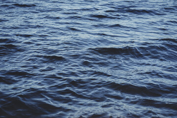 Close-up water surface, sun glare and blurred photo. Natural and abstract background.