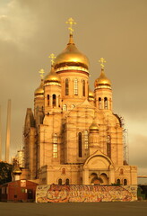 Obraz premium Catholic church with a golden dome on an orange sky background