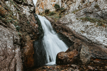 Small waterfall in mountain. Hiking and eco tourism in Caucasus mountain. Travel destinations.