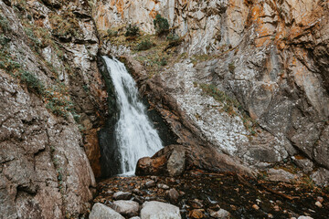 Small waterfall in mountain. Hiking and eco tourism in Caucasus mountain. Travel destinations.