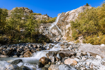 Fototapeta na wymiar Small waterfall in mountain. Hiking and eco tourism in Caucasus mountain. Travel destinations.