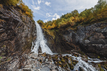 Small waterfall in mountain. Hiking and eco tourism in Caucasus mountain. Travel destinations.