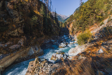 Canyon of mountain river with blue water. Autumn in Caucasus mountain. Hiking and eco tourism in mountain.
