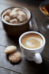 Cup of coffee with amaretti (Italian biscuits) on rustic wooden background. Close up.	
