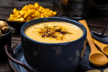 cheese cream soup with corn, pistachios and croutons on a rustic background. Restaurant menu, dieting, cookbook recipe