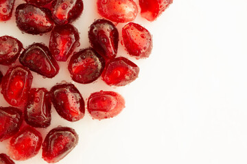 Pomegranate seeds on white background board.