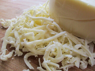 Grated cheese on a wooden board.
