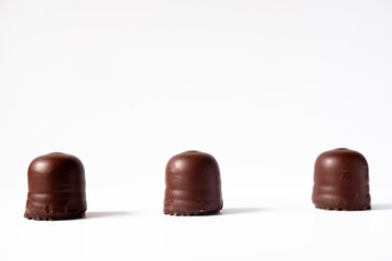 chocolate candies on a white background. Three chocolate brownies. Social distance in chocolates