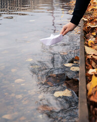 hand holding a paper boat  under the water 