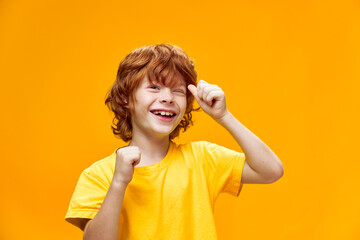 Happy child with red hair winks does not show thumb