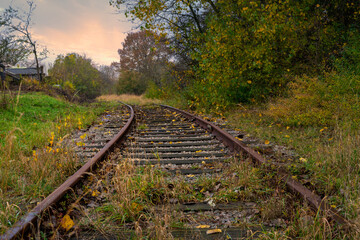 Fototapeta premium Railroad tracks with a dramatic sunset in the background. Picture from Scania county, Sweden