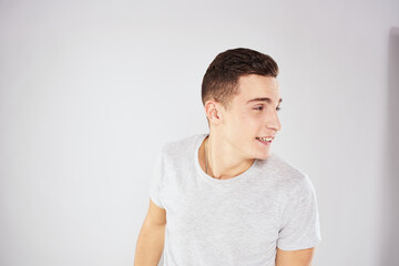 Fototapeta premium Man in a white t-shirt emotions gestures with hands close-up cropped view light background