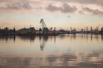 Lifting cranes in the distance on the embankment in the city