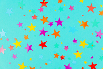 multicolored backdrop of colored stars confetti on a blue background.