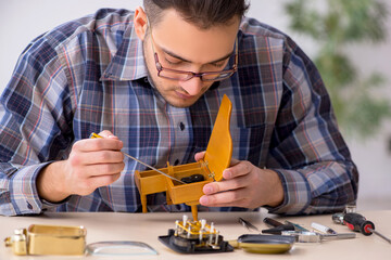 Young male watchmaker working in the workshop