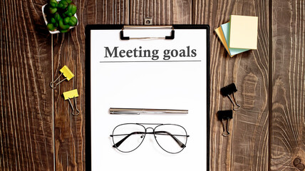 MEETING GOALS text form on a wooden table with office tips