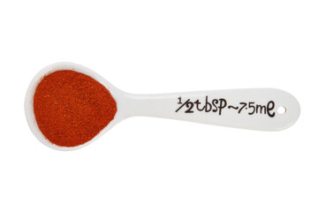 Closeup shot of a half tablespoon of ground paprika isolated on a white background