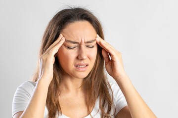 Fototapeta premium Girl suffering migraine on isolated gray background