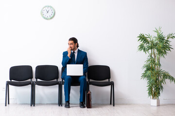 Young businessman waiting for an interview at hall