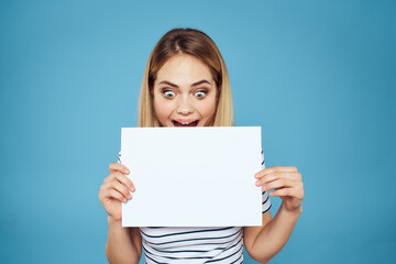 Fototapeta premium Woman holding sheet of paper striped T-shirt Copy Space cropped view blue background