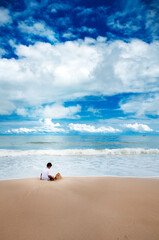Obraz premium Lone boy playing with sand on a beach