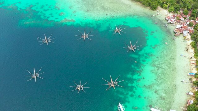 Aerial view of village of fishermen with houses on the water, with fishing boats, Samal island. Philippines, Mindanao.