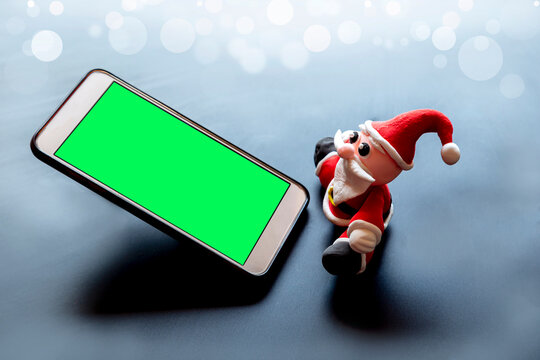 Santa claus staring mobile phone green screen The idea of ​​sending Christmas joy through social media is to prevent the spread of the virus and be a social distancing