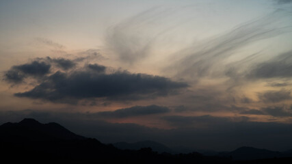 Dark clouds over black hills at dusk