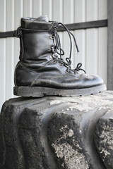Old, discarded, right, black, leather, military boot, in the trash