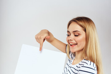 Naklejka premium woman holding a sheet of paper in her hands lifestyle striped t-shirt cropped view Copy Space