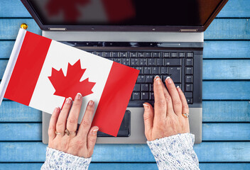 woman hands and flag of Canada on computer, laptop keyboard
