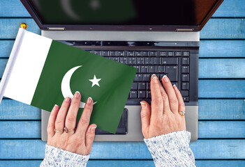 woman hands and flag of Pakistan on computer, laptop keyboard

