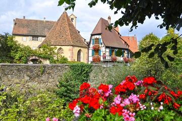 old house with  geranium flowers in small town Kaysersberg in France.